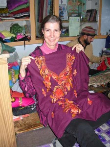 The tailor, sitting cross-legged behind me, works at a sewing machine on a low bench in front of him.